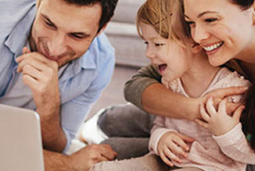 Young family happily in front of their laptop