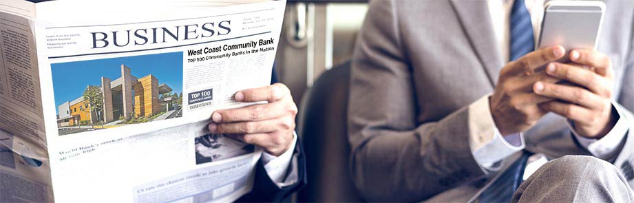 One person reading the business newspaper and one looking at their phone